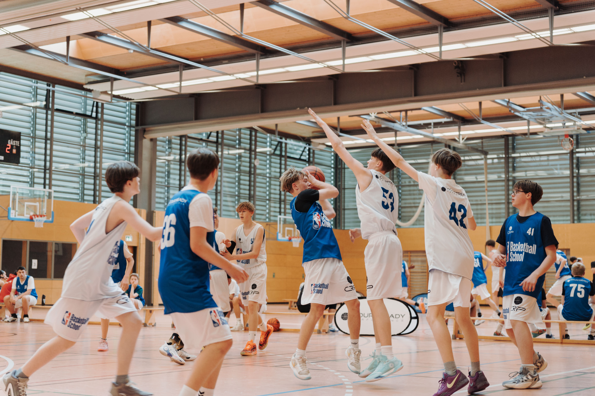 Jugendlicher Spieler zieht beim Training der NBA Basketball School zum Korb